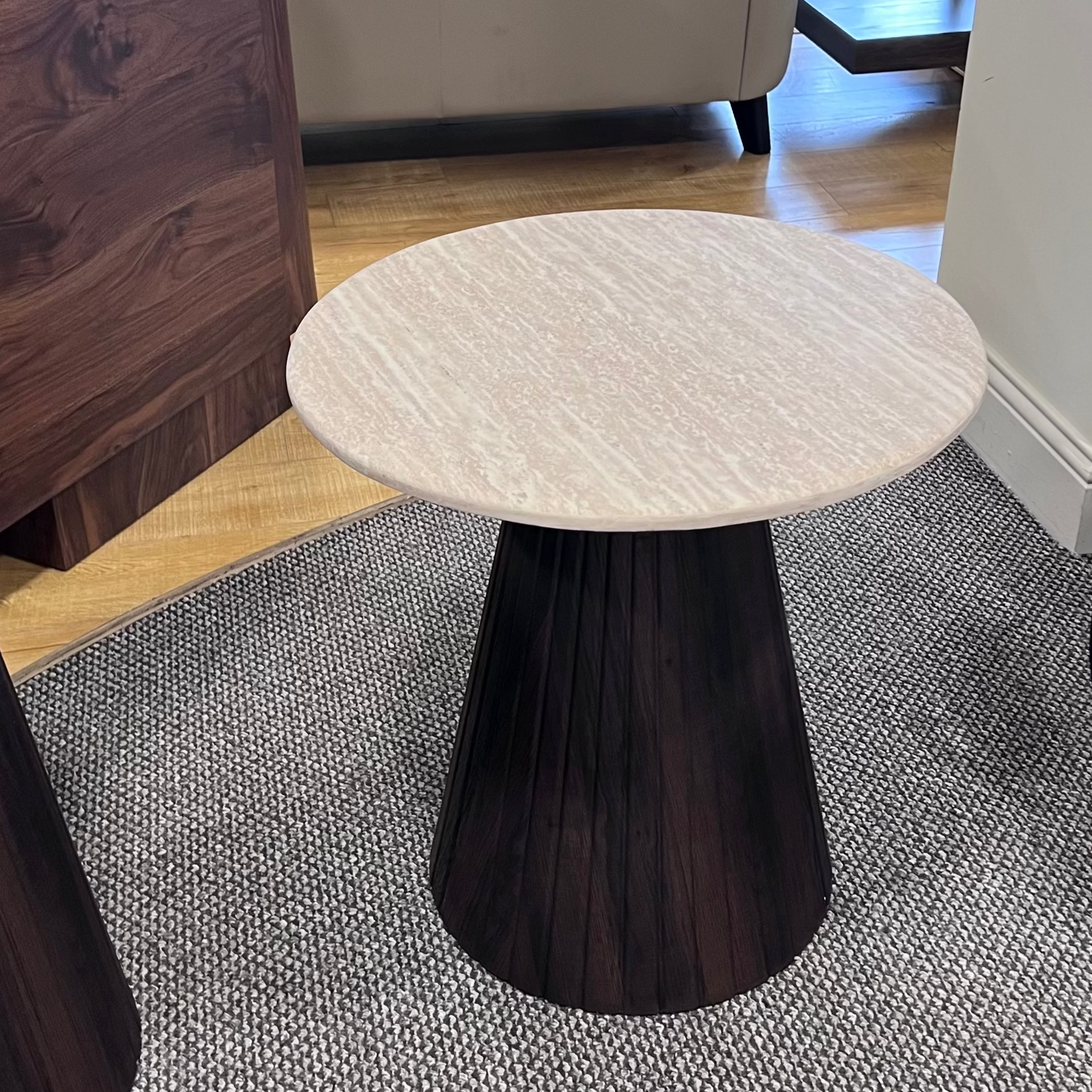 Round table with marble top and dark wood base in a room with furniture and decor.