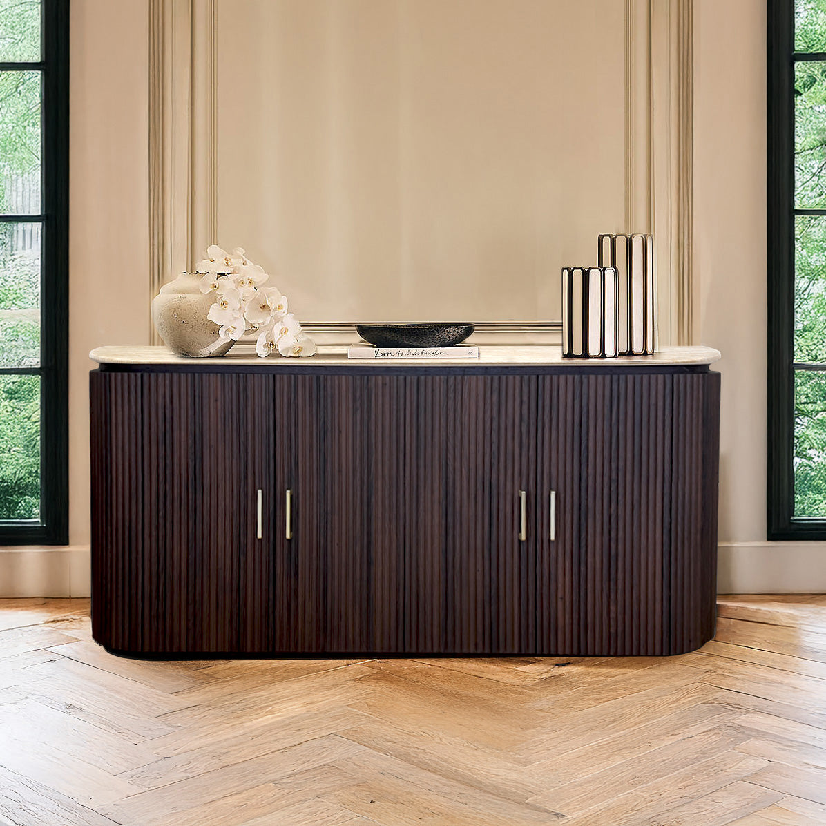 Dark wood sideboard with decorative items in a room with large windows.
