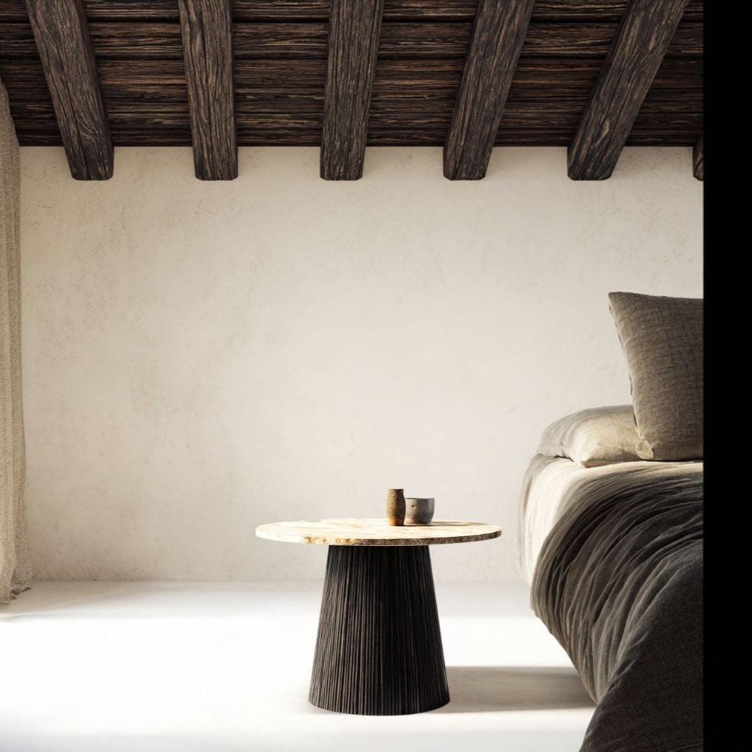 Minimalist bedroom with a bed, side table, and wooden ceiling beams.