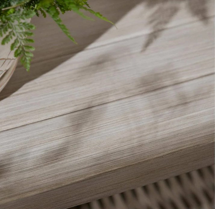 Close-up of a wooden surface with a plant in the corner