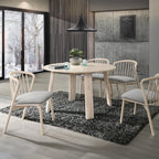 Dining room with round table and chairs on a gray rug, large windows showing snowy landscape.