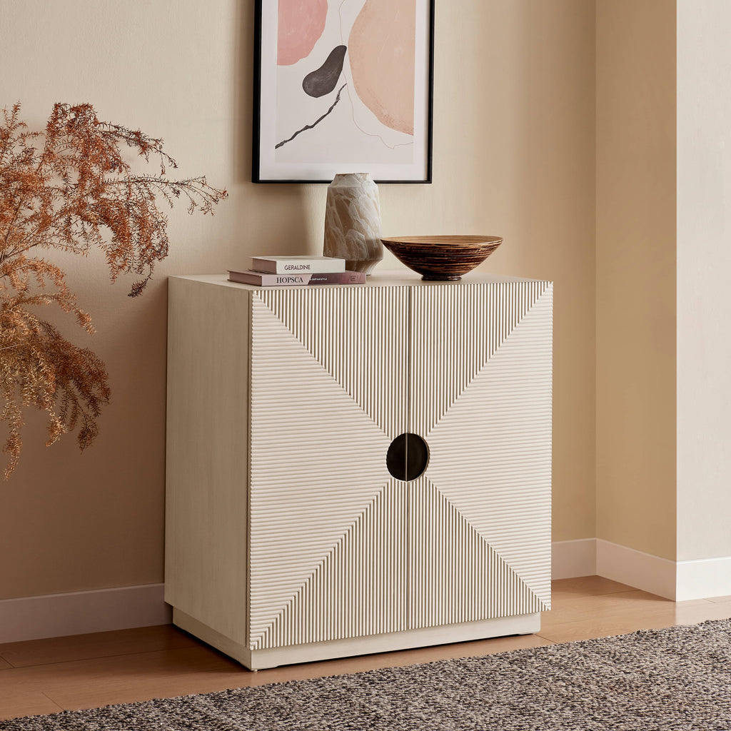 White cabinet with geometric design in a room with a plant and framed artwork on the wall.