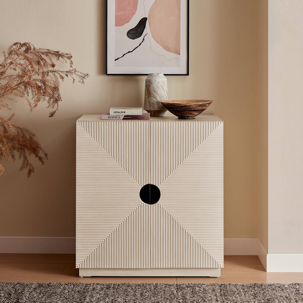Beige side table with geometric design in a room with abstract art on the wall.