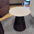 Round table with marble top and dark wood base in a room with furniture and decor.