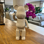 Textured bear figurine on a wooden table with a living room in the background