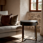 Round wooden table in a room with a stone wall and a sofa with pillows.