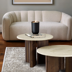 Beige sofa with a wooden coffee table and candle in a living room setting.