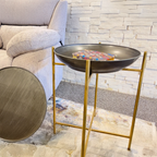 Decorative metal bowl on a stand in a living room setting