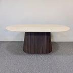 Round wooden table with a dark base on a gray floor.