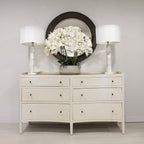 A Jacob Chest of 6 Drawers in French Grey, placed in a room setting with decorative items on top.