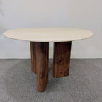 Round wooden table with a light-colored top on a gray carpeted floor.