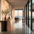 Modern interior with a console table, chairs, and large windows overlooking an ocean view.